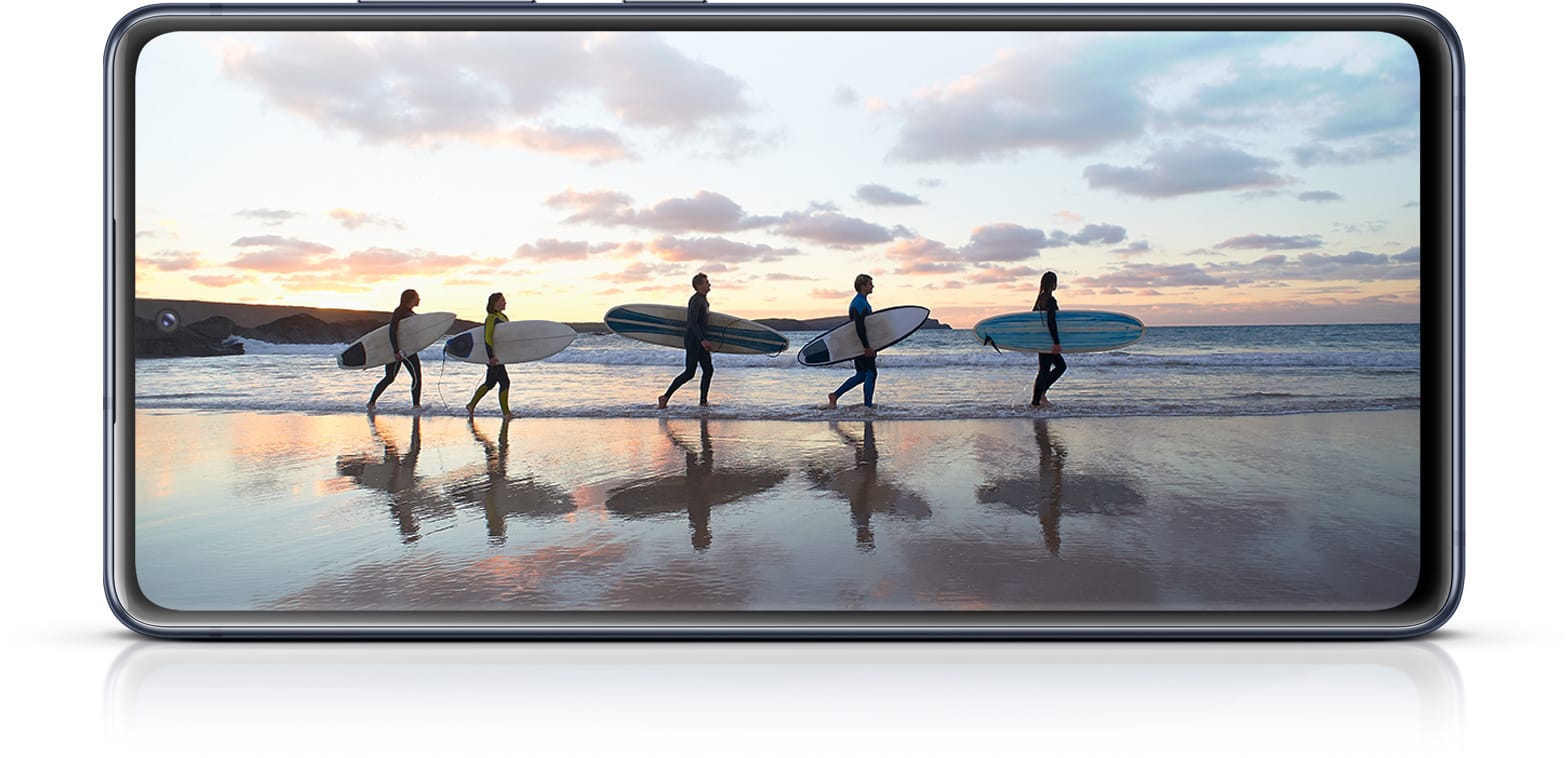 Galaxy S20 FE с фотографией серфера, иллюстрирующей иммерсивность экрана Infinity-O.